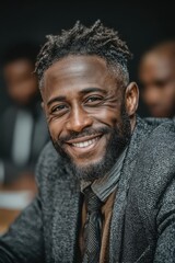 Fototapeta premium Well-dressed African American businessman with short hair smiles in a confident professional portrait
