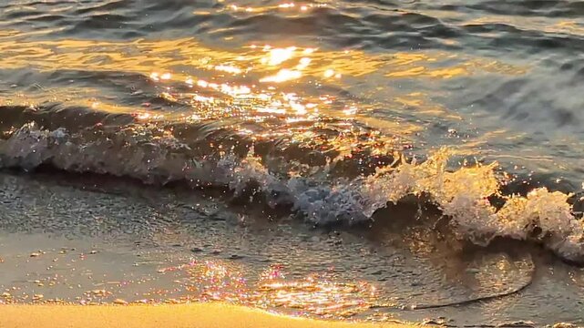 Le soleil levant embrase les vagues qui glissent vers la c&ocirc;te sablonneuse, formant un spectacle grandiose de lumi&egrave;re et de mouvement.