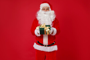 Santa Claus with Christmas gift on red background