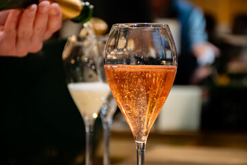 Pouring in glasses of french sparkling wine champagne with little bubbles, tasting wine, celebration, wedding or champagne tour with visit of caves, Reims, France