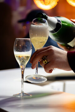 Pouring in glasses of french sparkling wine champagne with little bubbles, tasting wine, celebration, wedding or champagne tour with visit of caves, Reims, France