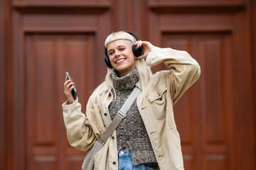 Happy woman listening to music on headphones outdoors