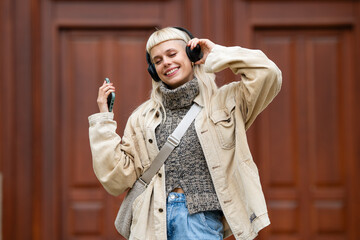 Young woman enjoying music with headphones on street