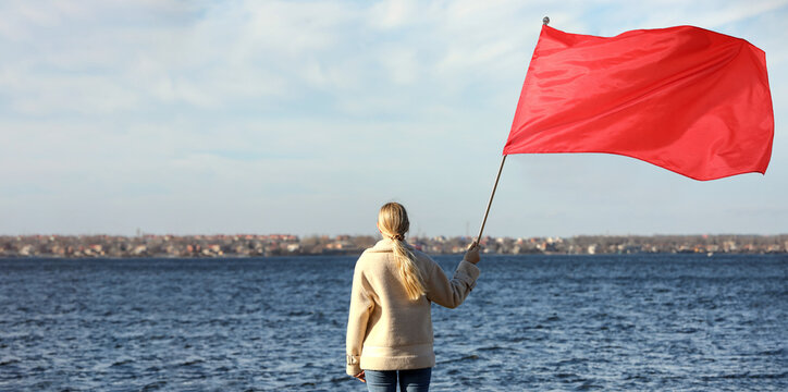 Woman with red flag near river outdoors. Banner design