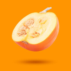 Half of pumpkin in air on orange background. Gourd vegetable