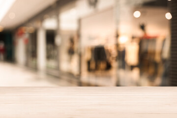 Empty wooden table against blurred view of shopping mall. Space for design