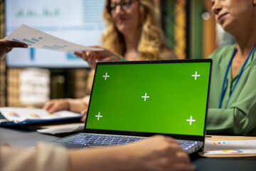 Group of business partners reviewing project analytics with green screen, empowered by data and...