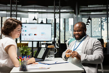 Black job seeker receives access credentials and photo ID badge from HR manager, finalizing the hiring process and joining the organization with confidence. Onboarding with access pass.