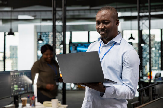 IT specialist in office automating repetitive business workflows using artificial intelligence tech on laptop. Engineer developer refining deep learning computational models with notebook