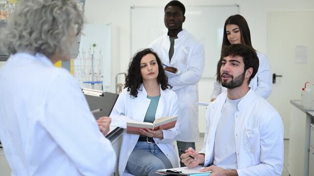 Professor teaching multicultural science students in university laboratory class