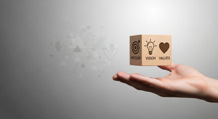 Hand holding wooden cube with mission, vision, values concepts