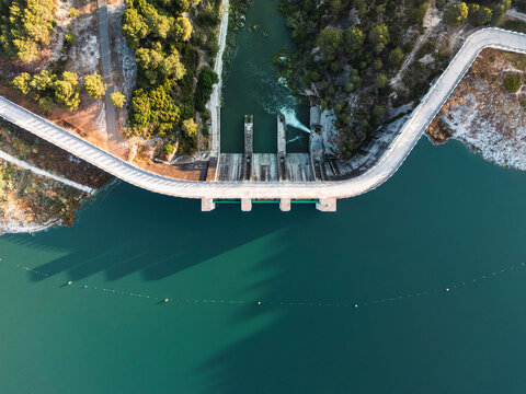Stunning drone photo of a curved dam and reservoir in South Spain, showcasing water management, engineering, and natural landscape for environmental and infrastructure concepts.