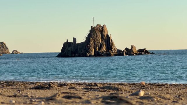 Isolated Sea (Scoglio dell Asseu) Stack with Cross Symbol in Calm Waters