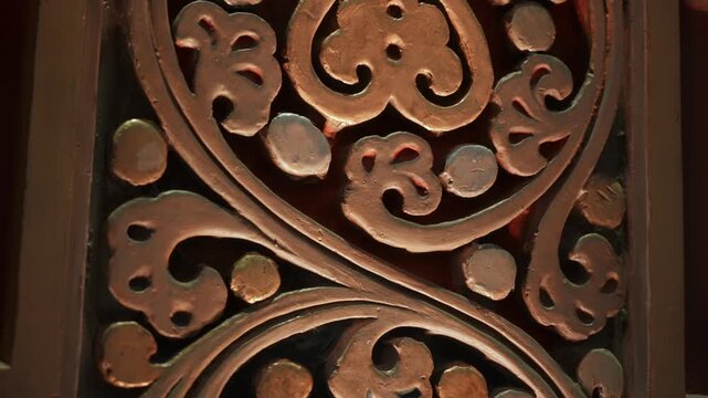 Tight Shot Carved Wooden Panel With Swirling Heart Motifs And Warm Patina, Master Woodcarver Polishing Surface Under Soft Workshop Light,
