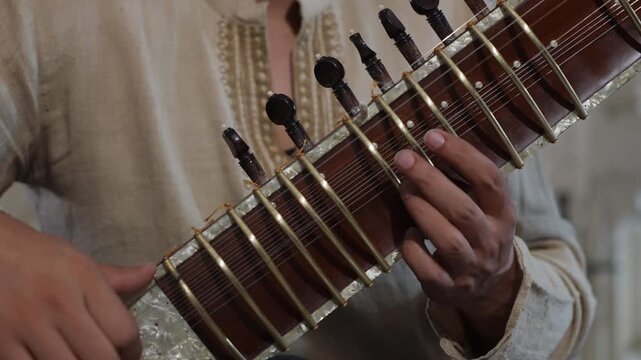 CloseUp Sitar Hands Plucking Strings In Intimate Home Studio, Session Musician Practicing Raga Phrases On Ornate Instrument, Warm Natural