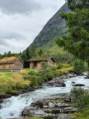 Traditional norwegian log cabins beside rushing river in valldal