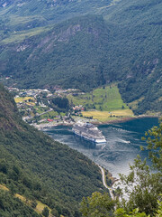 Cruise ship navigating geirangerfjord near geiranger village