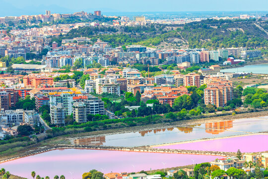 Cagliari Sardinia capital, overlooking pink waters of Molentargius Saline Regional Natural Park. Vibrant pink color is caused by salt bacteria and micro-algae that thrive in highly saline environment