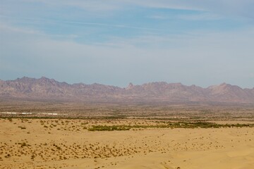 Train running through town by Imperial sand dunes with mountainous background in Glamis california