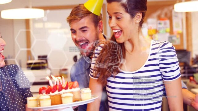 Male placing hat on female, sparking team bringing lit cupcakes, hex overlay for work birthday