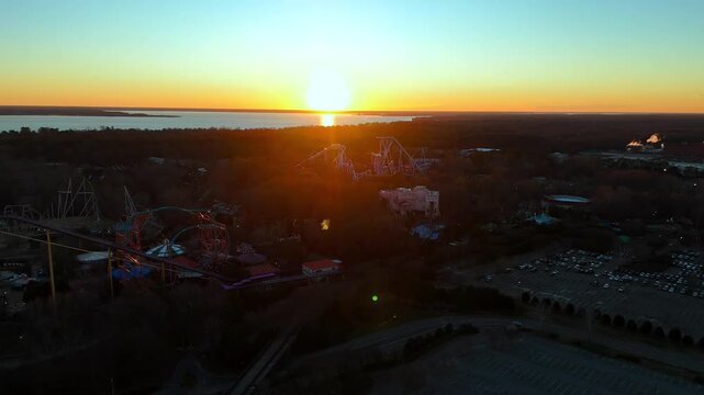 Wide Aerial of Roller Coaster Silhouettes in European Theme Park near James River in Williamsburg, Virginia during Sunset