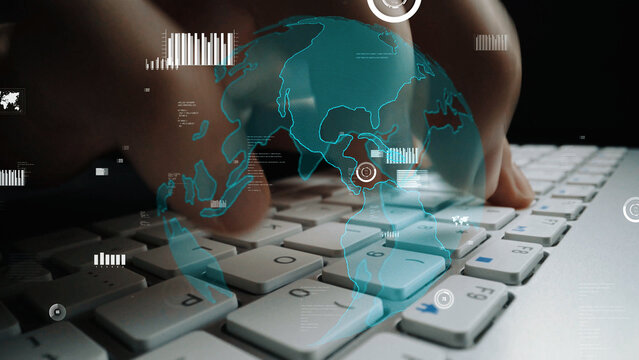 A close-up of hands typing on a modern keyboard is enhanced with a transparent digital globe overlay and data visualizations, representing technology and global connectivity. Xenic - Powered by Adobe