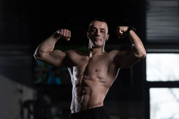 Fototapeta premium Bodybuilder Fitness Model Posing Double Biceps After Exercises