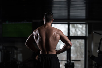 Obraz premium Muscular Man Flexing Back Muscles Pose