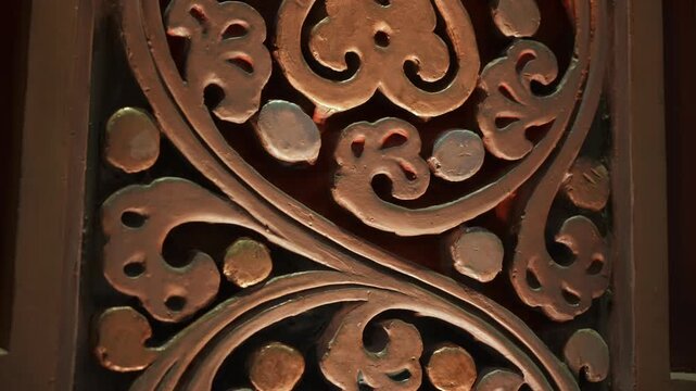 Tight Shot Carved Wooden Panel With Swirling Heart Motifs And Warm Patina, Master Woodcarver Polishing Surface Under Soft Workshop Light,