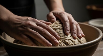 Hands kneading dough in a bowl for baking bread.