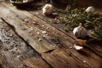 Obraz premium Garlic cloves and coarse salt scattered on rustic wooden surface for cooking