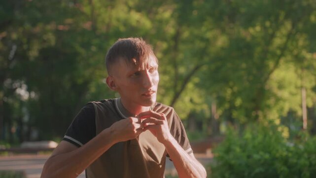White Man Fiddling With Collar And Buttons In Bright Park Light, CloseUp Reveals Repeated Pinching And Smoothing Motions, Tense Expression Suggesting Self Soothing Ritual And Inner Unrest