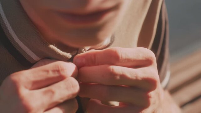 White Man CloseUp Buttoning Shirt Collar With Intense Finger Movements, Tight Framing On Hands And Face Highlights Texture Of Fabric, Concentrated Motion Suggests Compulsive Behavior And Anxiety