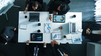 Top view of diverse business people brainstorm marketing idea and plan strategy. Professional businessman standing at whiteboard and explain financial plan while look at graph on table. Directorate.