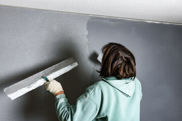 Applying concrete pebble plaster kornik using putty knife.