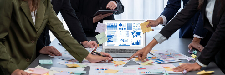 Analyst team use sticky note for creative and analytic brainstorm for business idea with BI data dashboard on laptop screen. Analysis financial data visualization tech for marketing strategy. Prodigy