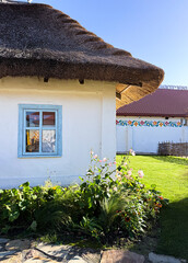 Traditional ukrainian house with thatched roof and blue window