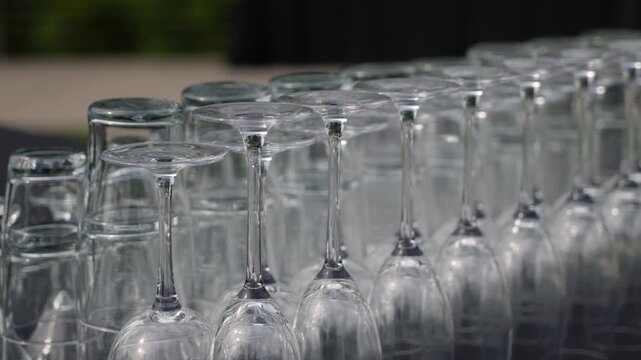 Rows Of Glassware Lined On Long Table, Inverted Crystal Stemware Polished And Arranged In Precise Rows, Soft Outdoor Light Creating