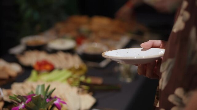 Guest Holding Plate At Buffet Hand Reaching For Appetizers Charcuterie Selection Blurred Background Casual Event Social Gathering Polite