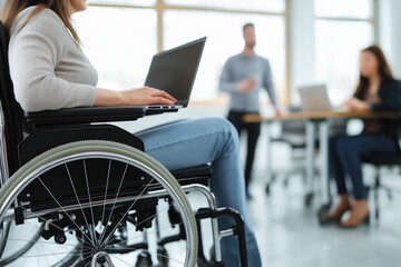 Woman in wheelchair using laptop in modern office with coworkers disability inclusion and accessible workplace for diverse team