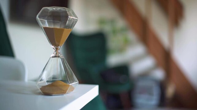 An hourglass on a table in a living room 4k