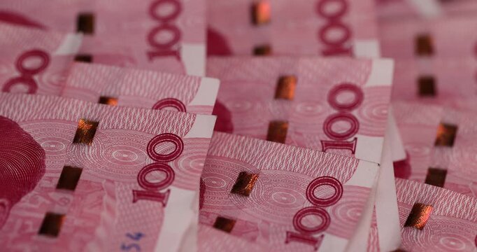red Chinese money in denominations of one hundred yuan, a pile of paper Chinese banknotes in denominations of 100 yuan