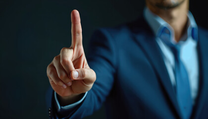 Man in blue suit raises index finger, conveying a directive or important insight. Formal attire signals pro context. Subtle focus implies thoughtful leadership.