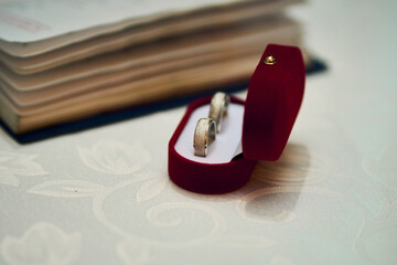A glimpse of a couple renewing their vows, exchanging rings, a view of rings in a marriage, placing them on their fingers, alongside a priest, at a wedding celebration. Love, ritual, togetherness.