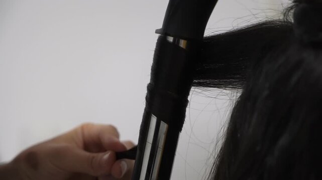 Stylist Curling Long Hair With Curling Iron CloseUp Hands Wrapping Section, Salon Tools Visible, Focused Technique And Finish