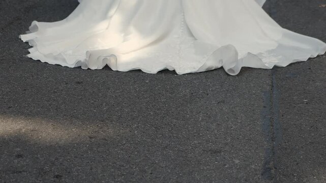 Wedding Dress Train On Pavement Under Sunlight, Flowing Hemline Sweeping Asphalt With Soft Shadows, Candid Urban Elopement Vibe Capturing