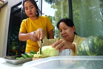 The daughter and mother collaboratively cutting cabbage, showcasing closeness and assistance.