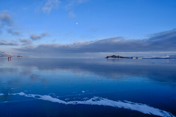 Baikal Lake in winter. Beautiful landscape with mountains reflected in ice of frozen Small Sea