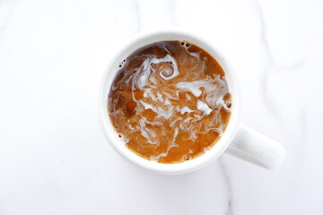 コーヒー - 淹れたてのコーヒーが入ったマグカップを、真上から俯瞰したイメージ
