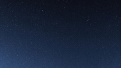Obraz premium A dark blue gradient background speckled with tiny white dots, evoking a night sky
